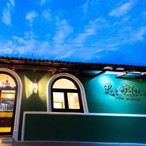 埃斯特利Hotel Los Altos Esteli的一座带两扇窗户和蓝色墙壁的建筑