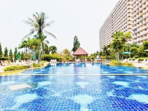 乔木提恩海滩Sea View Beachfront Condos Pattaya Jomtien Beach的棕榈树和建筑度假村的游泳池