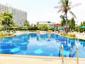 乔木提恩海滩Sea View Beachfront Condos Pattaya Jomtien Beach的一座棕榈树和建筑的大型游泳池