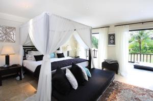 海神庙阿朱纳别墅酒店的一间卧室配有一张带天蓬的床