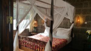 内罗毕伍德梅尔服务公寓式酒店的卧室配有带白色窗帘的天蓬床
