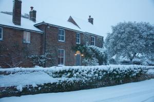 赫恩赫伦肖别墅酒店的院子里的雪覆盖的房子