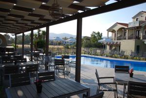 斯卡拉卡伦尼斯艾美提度假酒店的游泳池旁带桌椅的天井