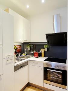柏林鲁默尔斯博格伯特安奥斯克罗茨公寓的厨房配有白色橱柜和炉灶烤箱。