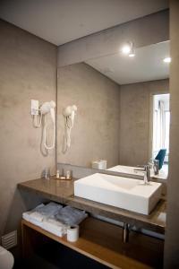 福斯·杜·阿勒奥心灵之水酒店的浴室设有大型白色水槽和镜子