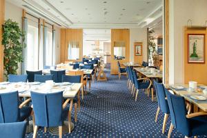 巴贝西斯特恩海滨酒店的餐厅设有木桌和蓝色椅子