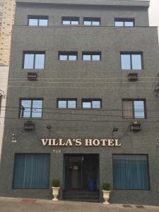 圣保罗Villas Hotel的一座带有标志的建筑,上面写着别墅酒店