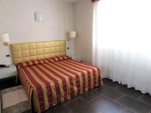 曼托瓦丹特公寓酒店的一间卧室配有一张带红色和黄色毯子的床