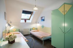 布达佩斯MP Hostel Budapest的客房设有两张床、一张桌子和一扇窗户。