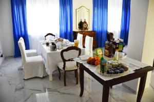 都灵卡萨妮萨住宿加早餐旅馆的一间设有白色桌子和蓝色窗帘的用餐室