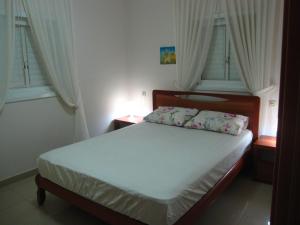 内坦亚Ocean View Luxury apartment的一间卧室配有一张带白色床单和窗户的床。