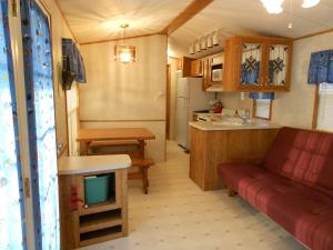 因莱特O'Connell's RV Campground Park Model 34的客厅和厨房,大篷车内摆放着红色沙发