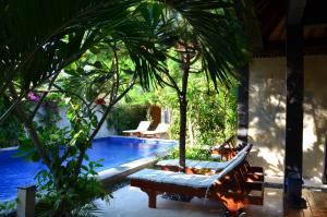 吉利阿尔塔曼瑟南住宿加早餐旅馆的一个带2把躺椅和棕榈树的度假游泳池