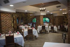 卡萨米尔利维亚酒店的一间设有白色桌椅和砖墙的餐厅