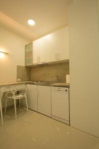 贝尔格莱德Apartments Jevremova的厨房配有白色橱柜、桌子和水槽。