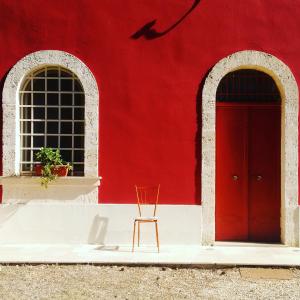 圣维托诺曼Il Boschetto的红色的建筑,有红色的门和椅子