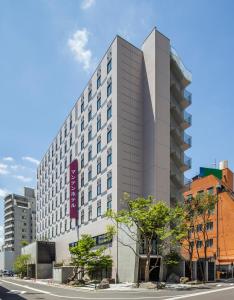 福井福井曼藤伊可玛酒店的一条城市街道上高大的白色建筑