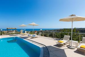 阿德里安诺斯坎波斯Diamantis Villa, a SeaView Retreat, By ThinkVilla的一个带椅子和遮阳伞的游泳池以及大海