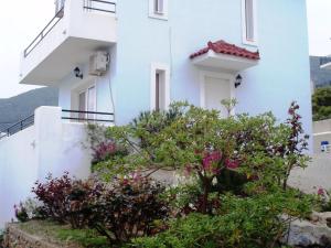 Agía ParaskevíBeautiful Villa in Agia Paraskevi Samos的前面有鲜花的白色建筑