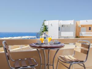 卡拉塔斯亚历山大别墅酒店的阳台配有一张桌子和两把椅子,享有海景