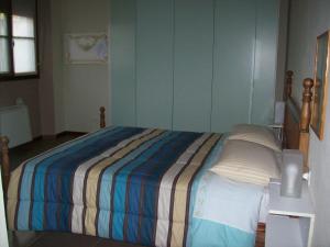 Vanzaghello拉柏特伽戴尔发勒内姆酒店的小卧室配有带条纹毯子的床