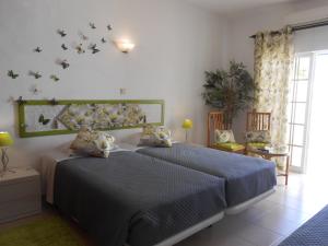 拉戈斯唐娜安娜花园旅馆的一间卧室设有两张床和窗户。
