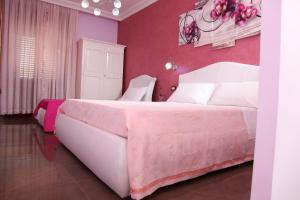 切萨雷奥港Palazzo Primavera的一间卧室配有一张带粉红色墙壁的大床