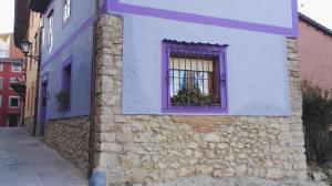利亚内斯La Casina de Llanes的一座带紫色窗户的建筑