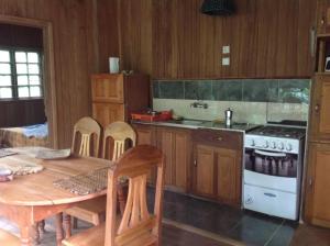 TrindadeCasa Ediana的厨房配有桌子和炉灶。 顶部烤箱