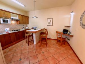 瓜达拉哈拉艾尔卡扎套房酒店的一间厨房,里面配有桌椅