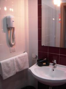 托雷拉皮罗Il Sole Il Mare Il Vento的一间带水槽的浴室和墙上的一部电话