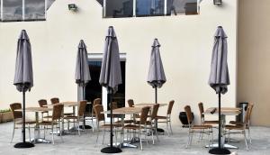 滨海阿热莱斯Hotel Bleu Azur的一组灰色的伞和桌椅