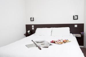 图卢兹At家庭公寓酒店的一张白色的床,上面放着一盘食物
