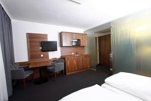 维也纳艾姆克尔公园酒店的酒店客房设有书桌、电视和床。