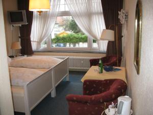 巴特萨尔茨乌夫伦科维拉福斯盯堡林酒店的卧室配有床、椅子和窗户。