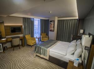 伯萨Grand Turkuaz Hotel的配有一张床和一张书桌的酒店客房