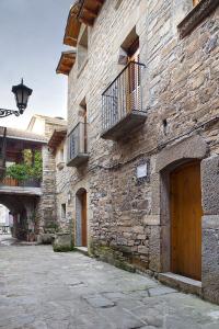 El Pueyo de AraguásCasa Encuentra, en el Pirineo al lado de Ainsa的石头建筑,设有木门和阳台