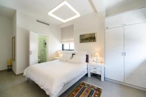 特拉维夫Sunny Luxury Apartments的白色卧室配有白色的床和白色衣柜