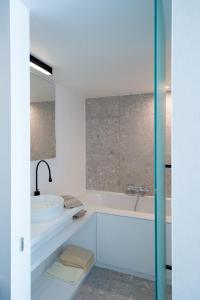 奥斯坦德公主酒店的白色的浴室设有浴缸和水槽。