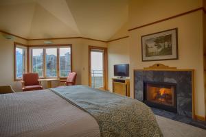 卡农海滩波浪酒店的一间卧室配有一张床和一个壁炉