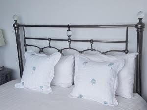 拉恩中途之家酒店的一张带两个白色枕头和金属床头板的床