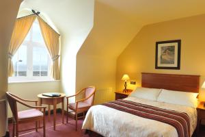 班多伦菲茨杰拉德酒店的卧室配有一张床和一张桌子及椅子