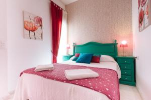 塞维利亚维吉内斯公寓的一间卧室配有一张带绿色床头板的床