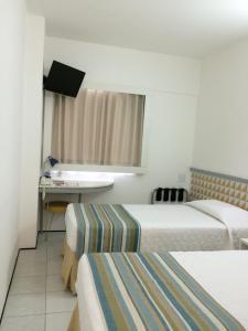 萨尔瓦多Ibis Budget Salvador的酒店客房配有两张床和一张书桌