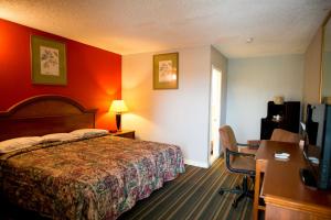 本赛霖姆Scottish Inn and Suites - Bensalem-Philadelphia的酒店客房配有一张床、一张书桌和一台电视。