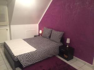 蒂艾L'Eden Orly Aéroport的一间卧室配有一张紫色墙壁的床