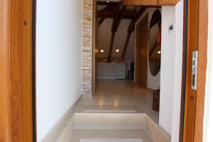 杜布罗夫尼克Dubrovnik Rupe Apartment的走廊设有瓷砖地板和砖墙