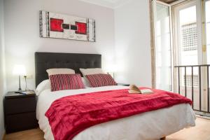 圣地亚哥－德孔波斯特拉Xavestre Rooms Santiago的一间卧室配有一张带红色毯子的大床
