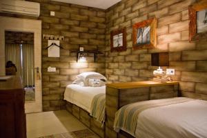 佩尼契Surfers Lodge Peniche的一间带两张床铺的卧室,位于带木墙的房间内