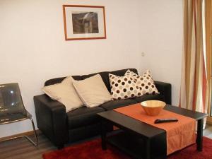 巴特欣德朗Heulandhof的客厅配有黑色沙发和桌子